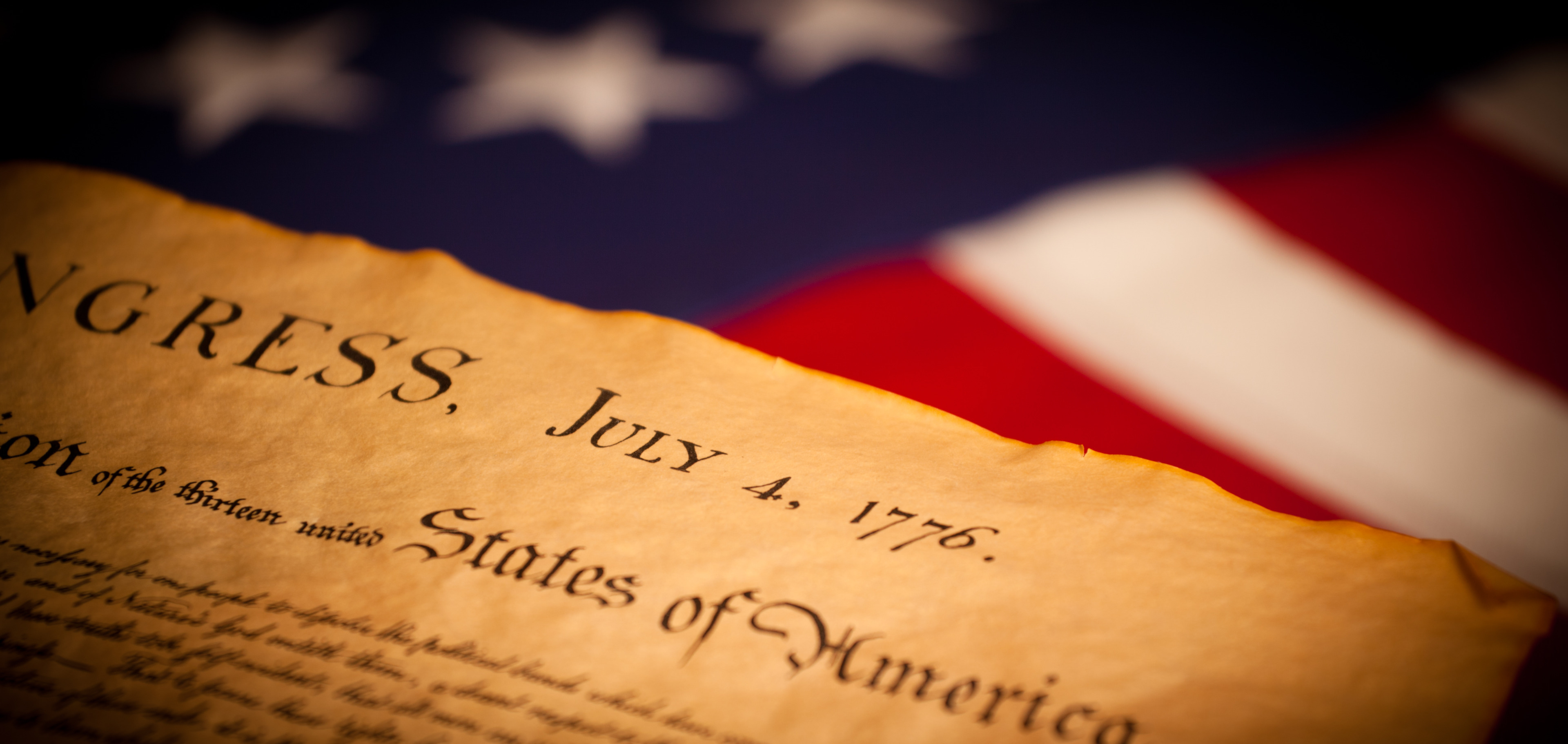 The Declaration of Independence, dated July 4, 1776, beside an American flag.